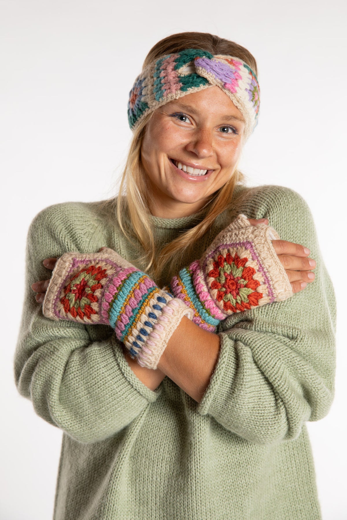 Sophie is wearing the Granny Square Wool Fingerless Mittens in Natural