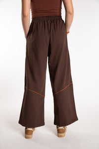 Emily is wearing the Brown Himal Contrast Stitch Sweatpants in S/M