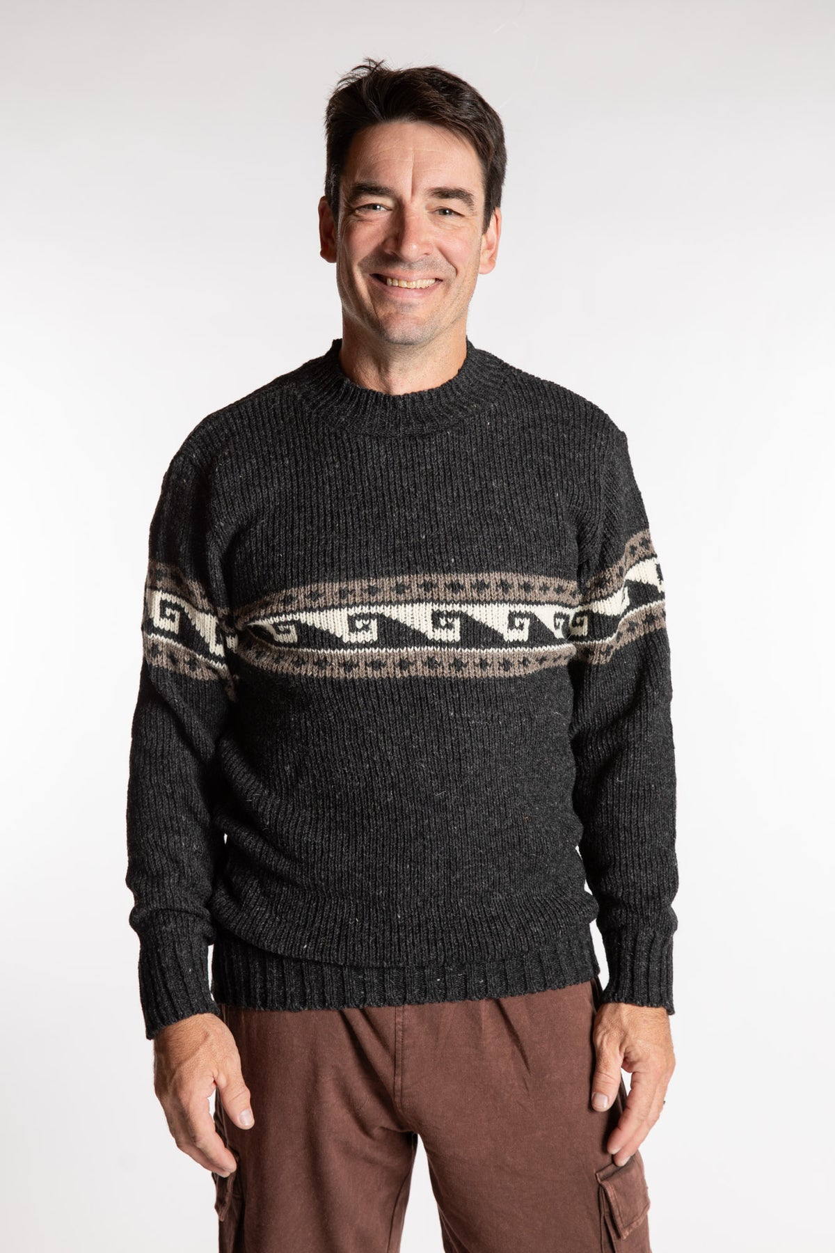 Topher is wearing the Large Himalayan Patterned Wool Sweater in Charcoal Wave