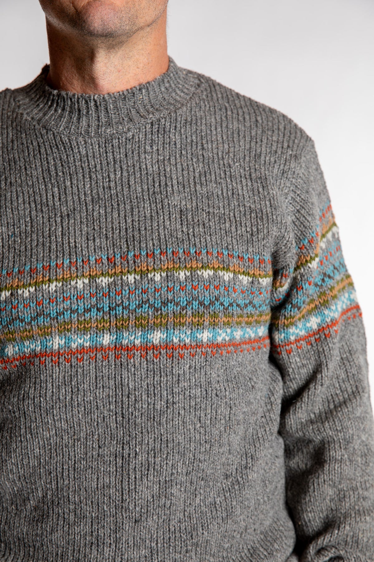 Topher is wearing the Large Himalayan Patterned Wool Sweater in Natural Multi