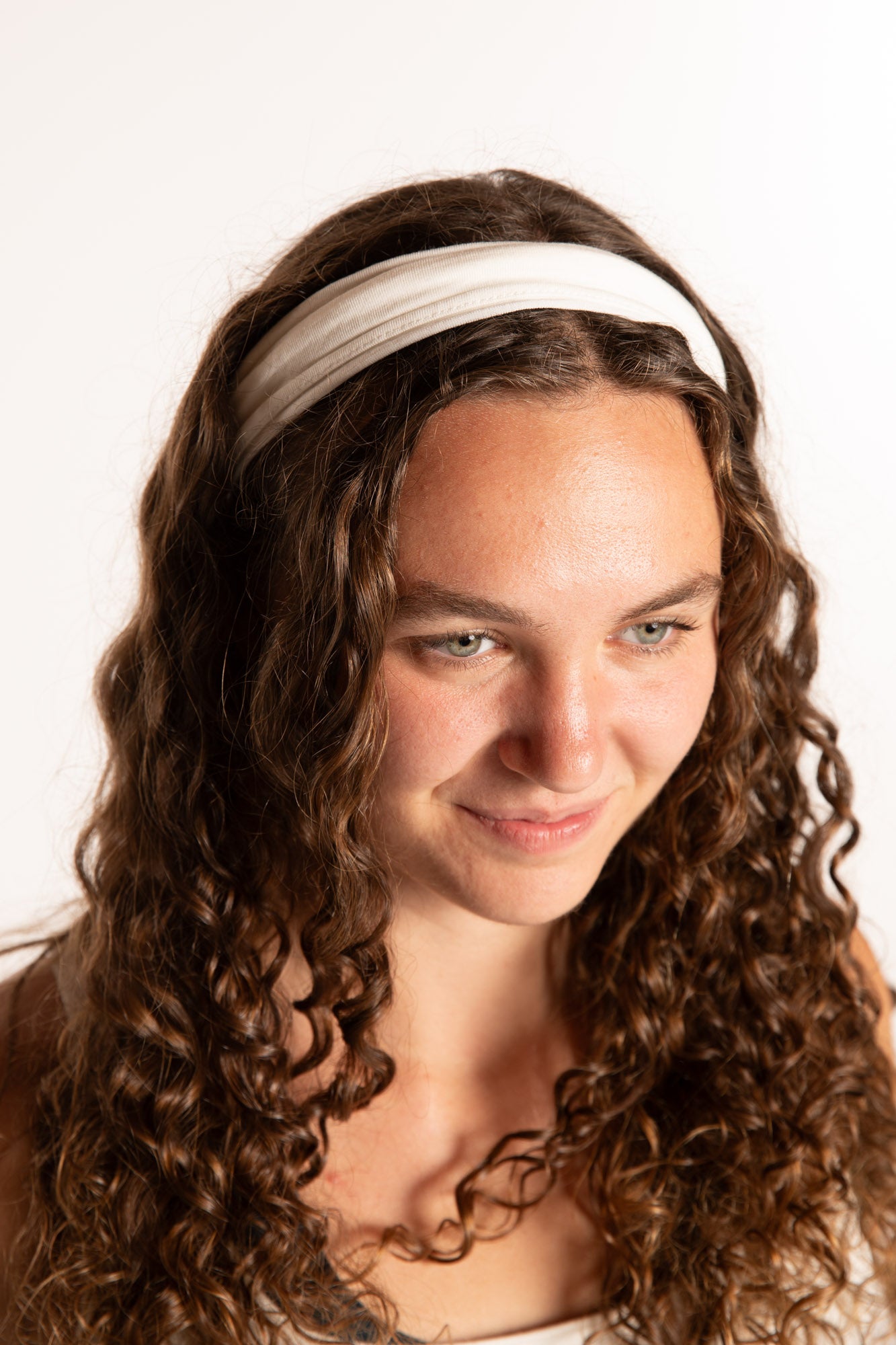 Emily is wearing the Indra Stretch Headband in Ivory