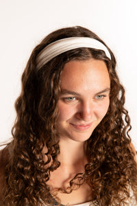 Emily is wearing the Indra Stretch Headband in Ivory