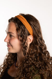 Emily is wearing the Indra Stretch Headband in Yellow