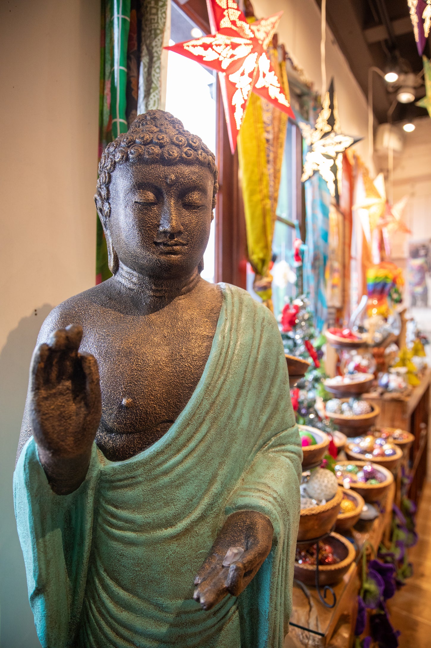 Large Buddha statue greeting Mexicali Blues customers in our Portland, Maine location with all kinds colorful products and star lanterns in the background