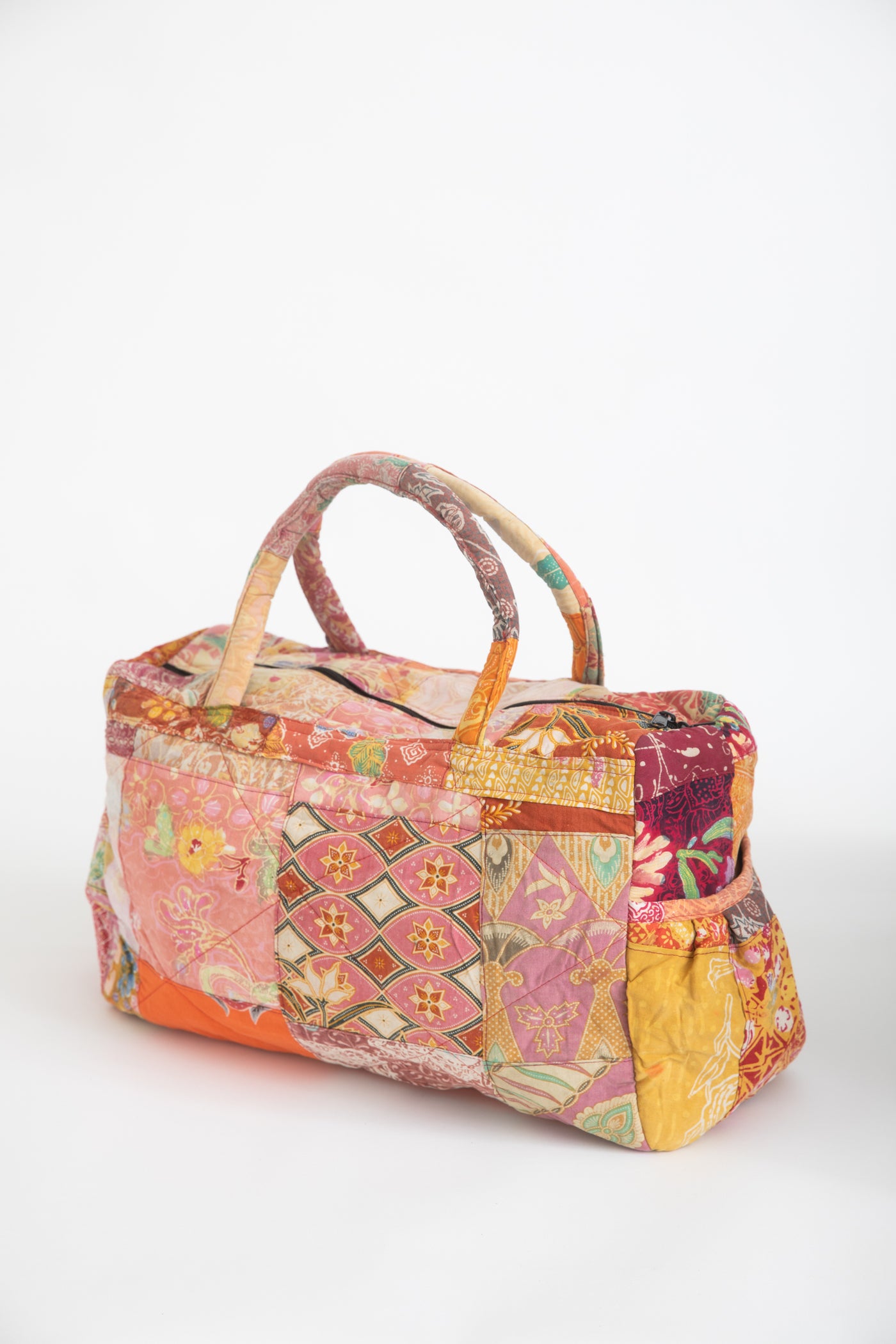 Assorted multicolor patchwork weekend bag on a white background