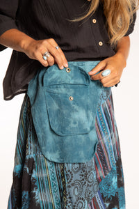 Sophie is wearing the Teal Jaya Patchwork Utility Wrap Skirt in S/M