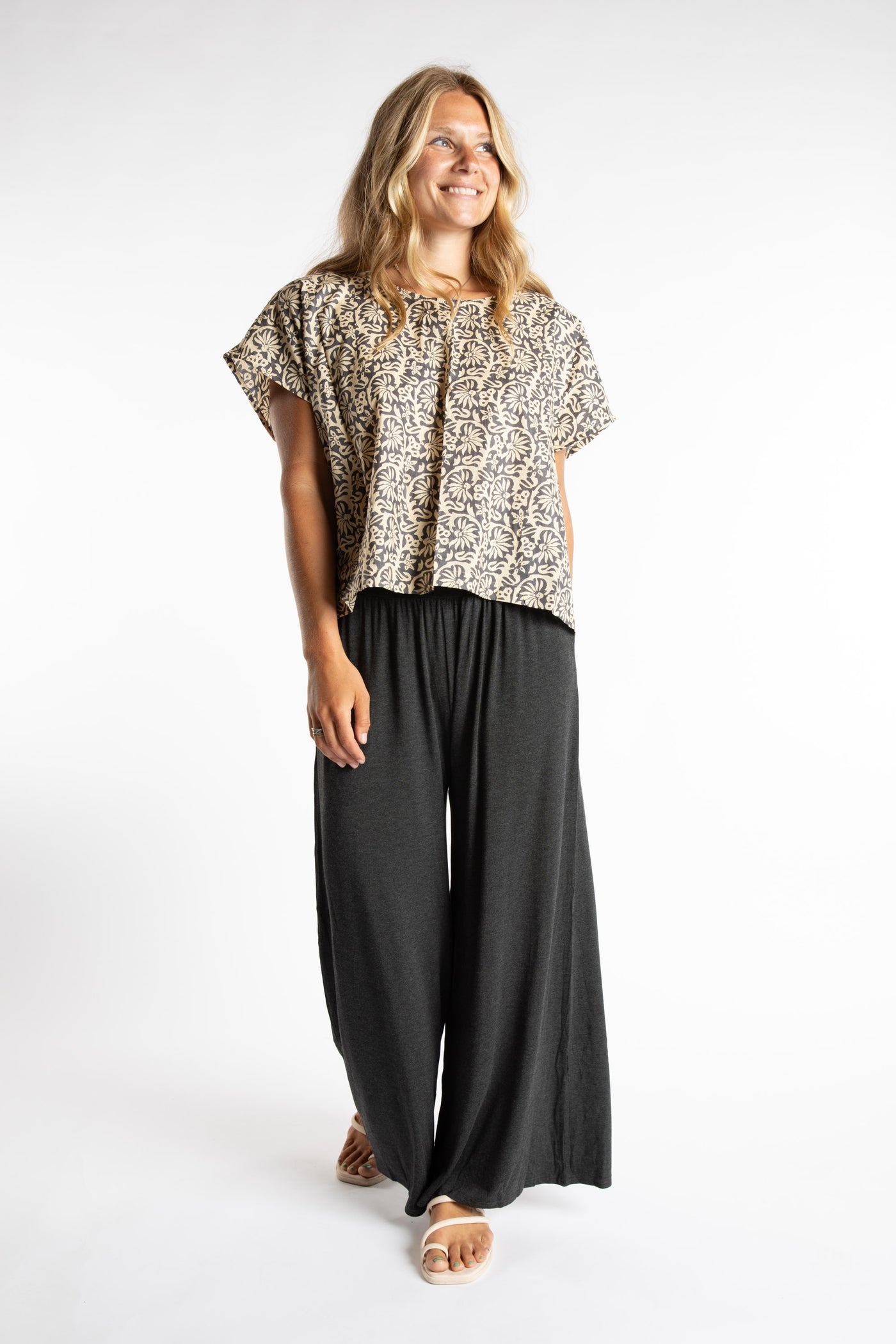 Sophie is wearing S/M Wide Leg Pants in Gray with a printed cotton top