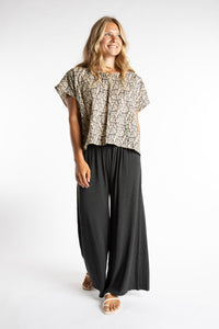 Sophie is wearing S/M Wide Leg Pants in Gray with a printed cotton top