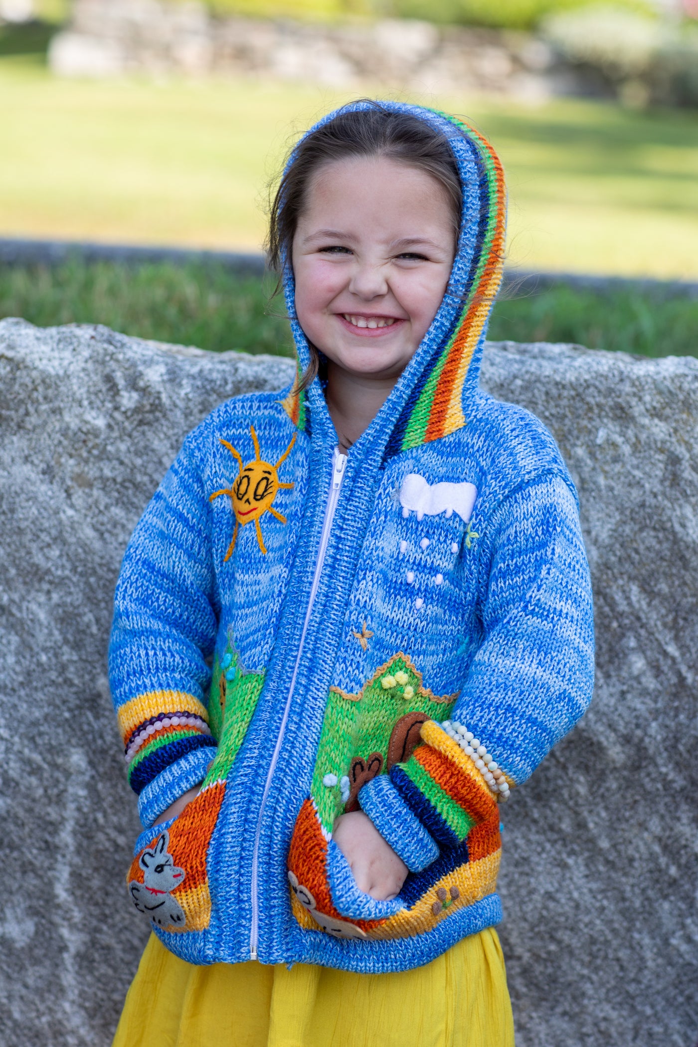 Lilly is wearing a kids nature scene sweater in blue