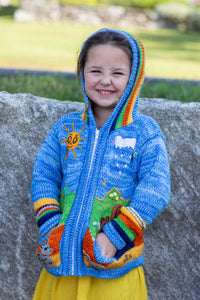 Lilly is wearing a kids nature scene sweater in blue