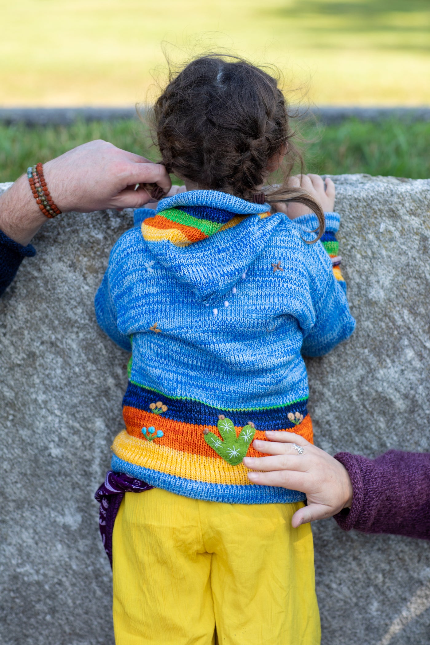 Lilly is wearing a kids nature scene sweater in blue