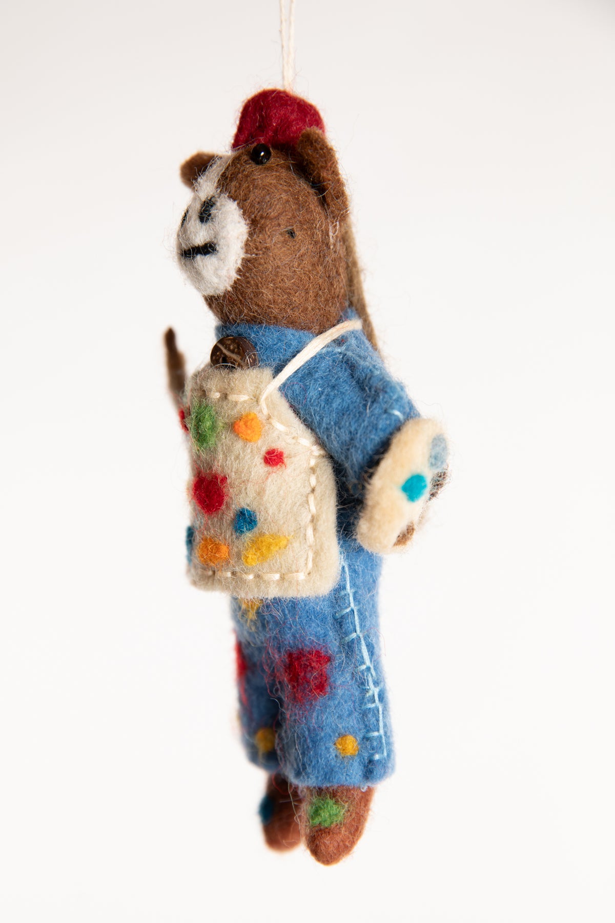 A felted horse ornament with blue overalls, holding a palette and wearing a painter's apron