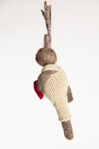 The side os a felted reindeer ornament with white overalls and a holding a felt heart