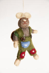 The front of a felted wool mouse ornament with a brown backpack and wearing green overalls with red and blue patches