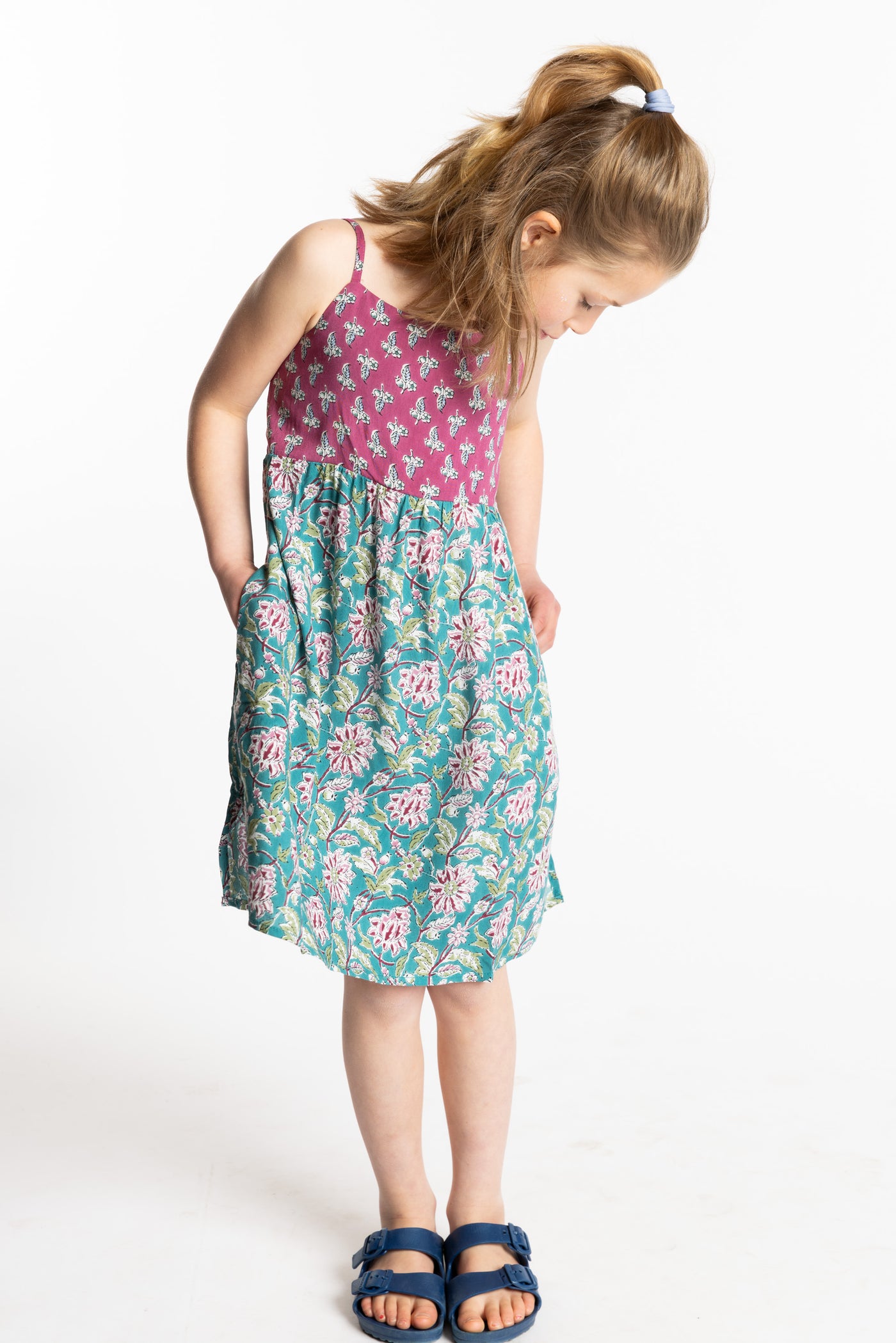 Louisa is wearing the size M Aqua floral kids dress with smocked back
