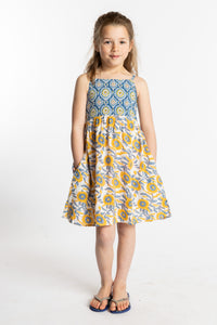 Louisa is wearing the size M sunflower floral kids dress with smocked back