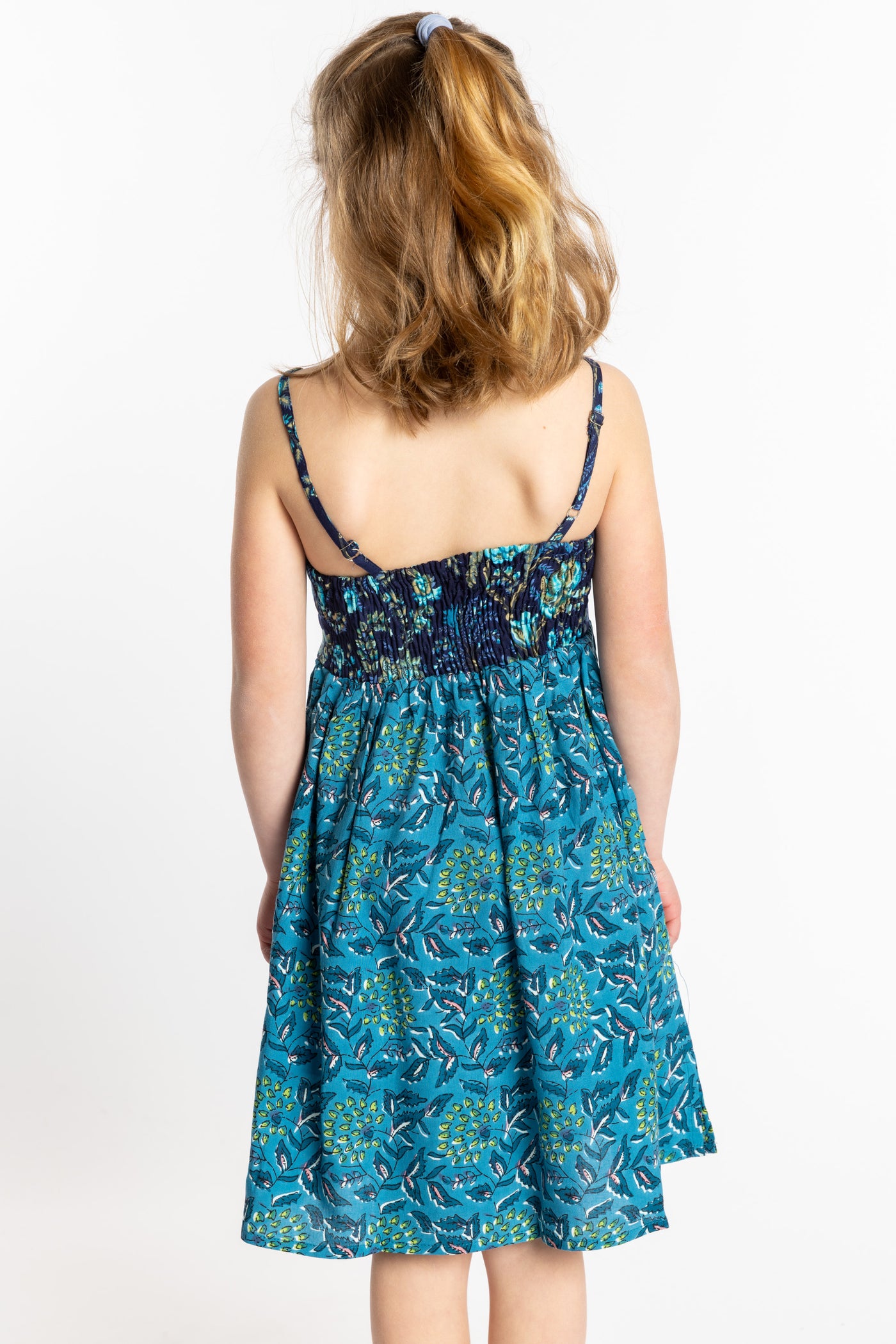 Louisa is wearing the size M teal floral kids dress with smocked back