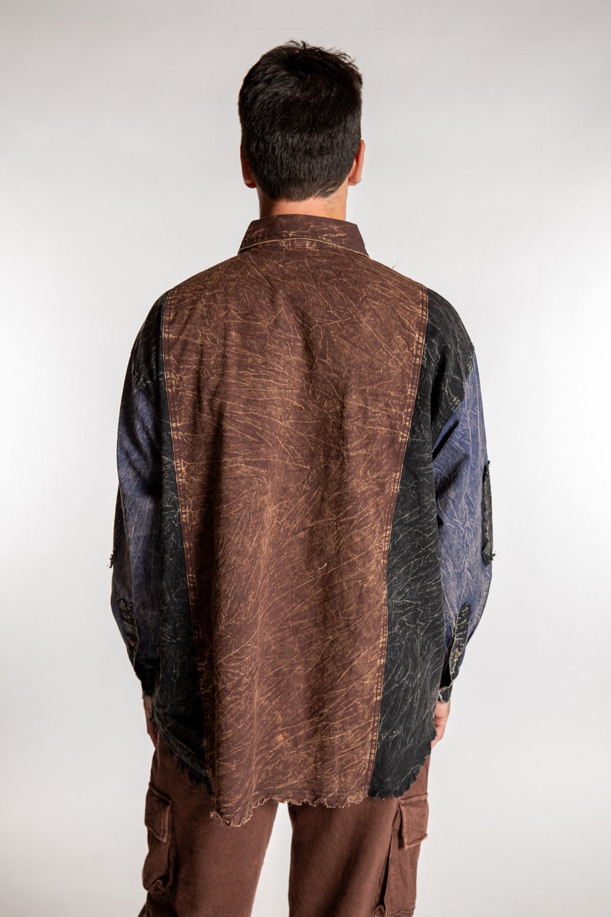Topher is wearing the One Size Makalu Patchwork Overshirt in North Sea