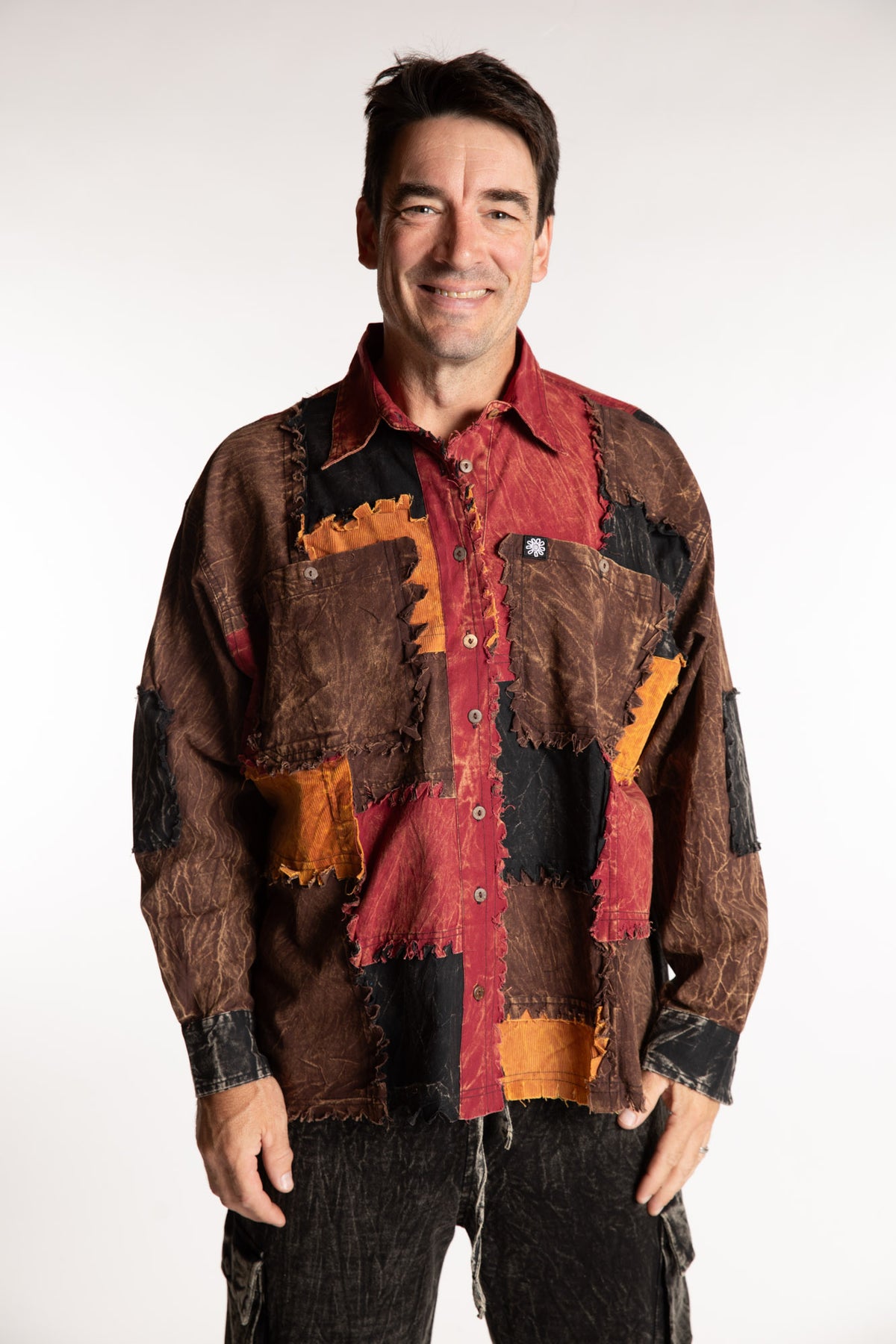 Topher is wearing the One Size Makalu Patchwork Overshirt in Spice Harvest