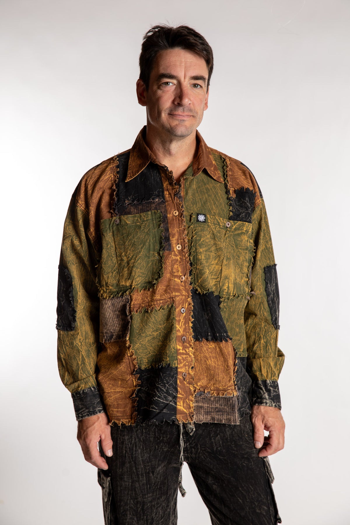 Topher is wearing the One Size Makalu Patchwork Overshirt in Timberline