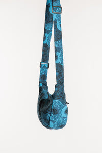 Side view of blue mandala crescent bag showing curved silhouette and adjustable strap
