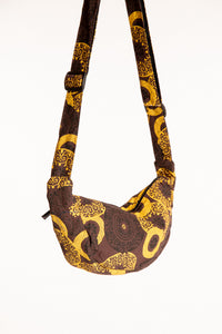 A brown mandala crescent crossbody bag with a wide adjustable strap