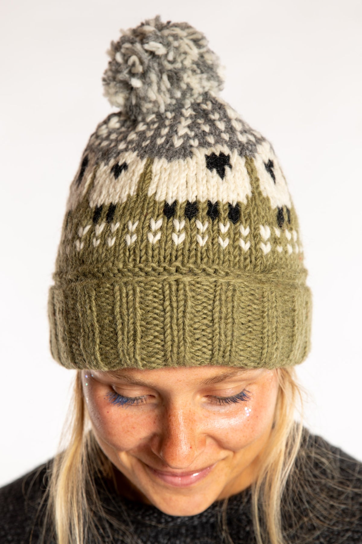 Sophie is wearing the Meadow Sheep Patterned Wool Pom Beanie in Fern