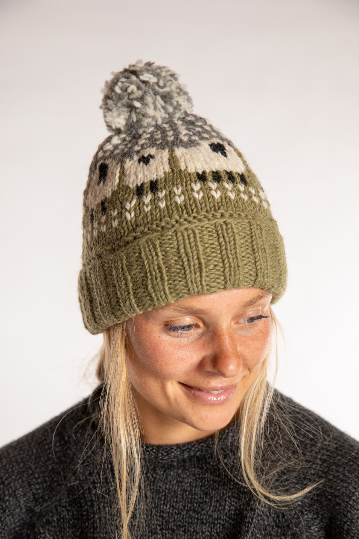 Sophie is wearing the Meadow Sheep Patterned Wool Pom Beanie in Fern