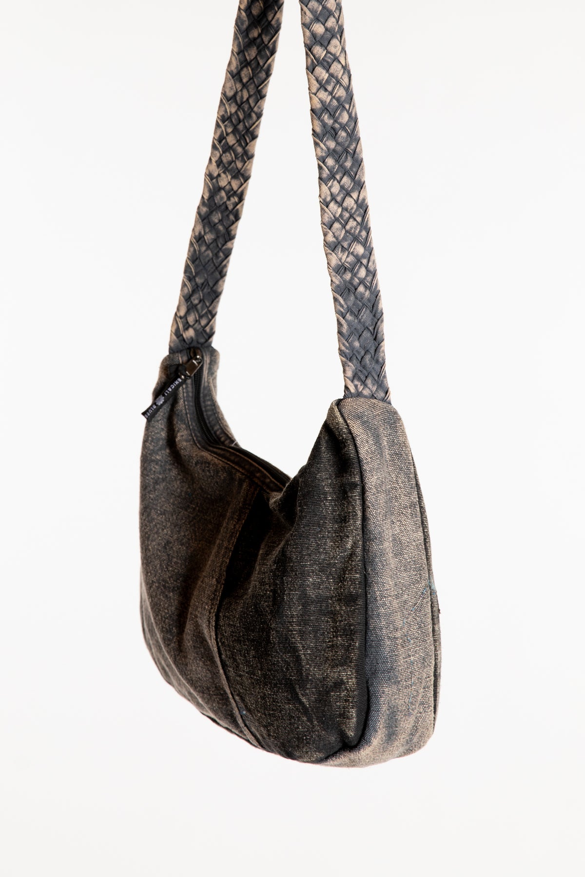 A black patchwork petals shoulder bag with a woven patterned strap
