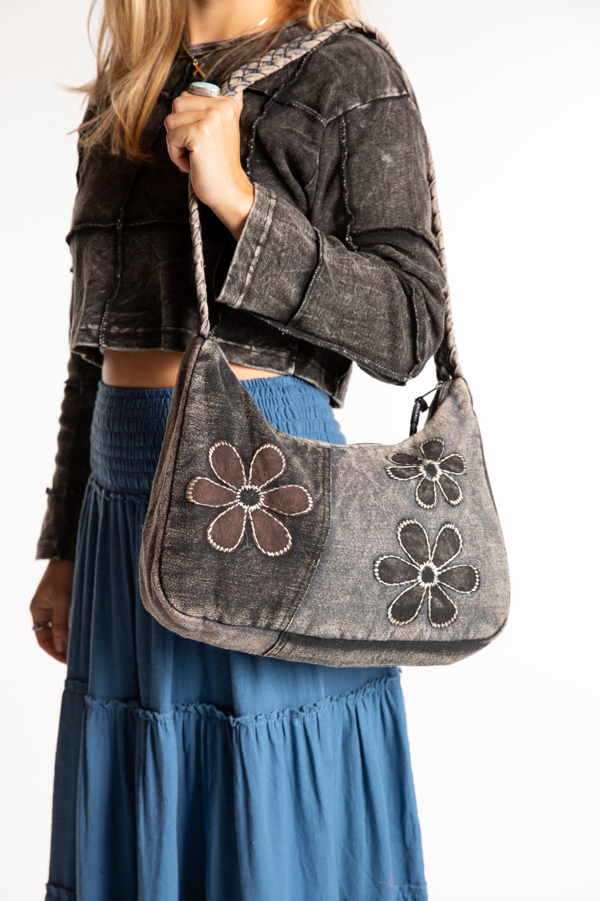 Sophie is wearing a black patchwork petals shoulder bag with embroidered flower details