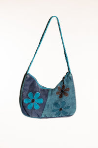 A blue patchwork petals shoulder bag  with embroidered flowers on the front