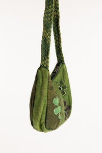 Side view of green patchwork shoulder bag showing slouchy shape and braided strap