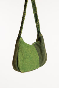 Side view of green patchwork shoulder bag showing slouchy shape and braided strap