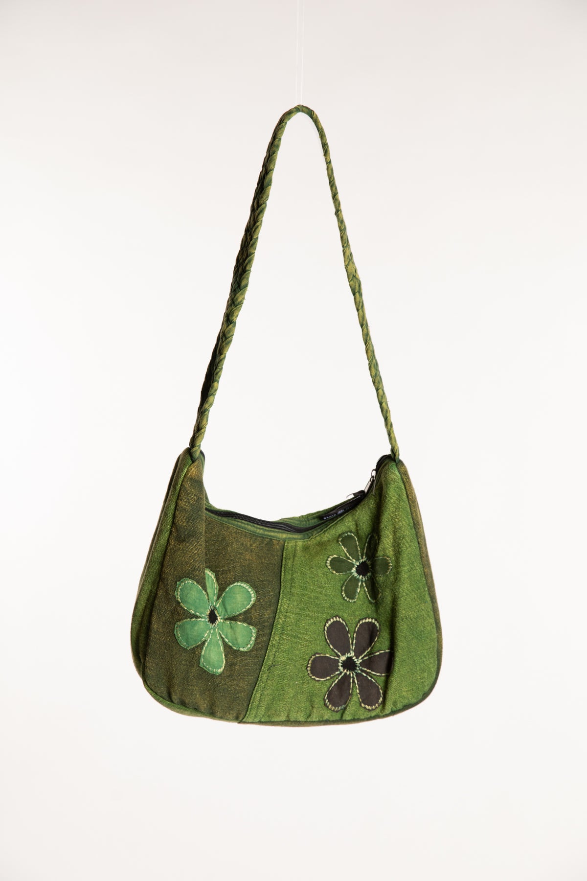 Green cotton patchwork shoulder bag with floral detailing and braided strap