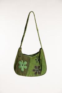 Green cotton patchwork shoulder bag with floral detailing and braided strap