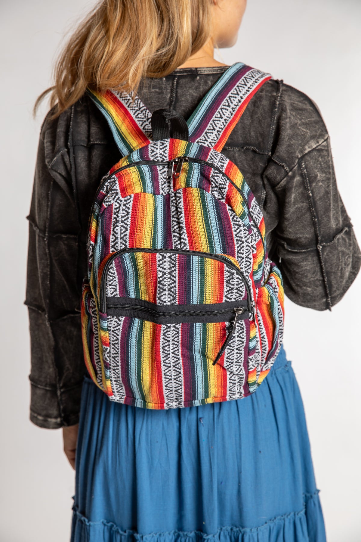 Close view of colorful Gheri striped backpack worn on Sophie's back