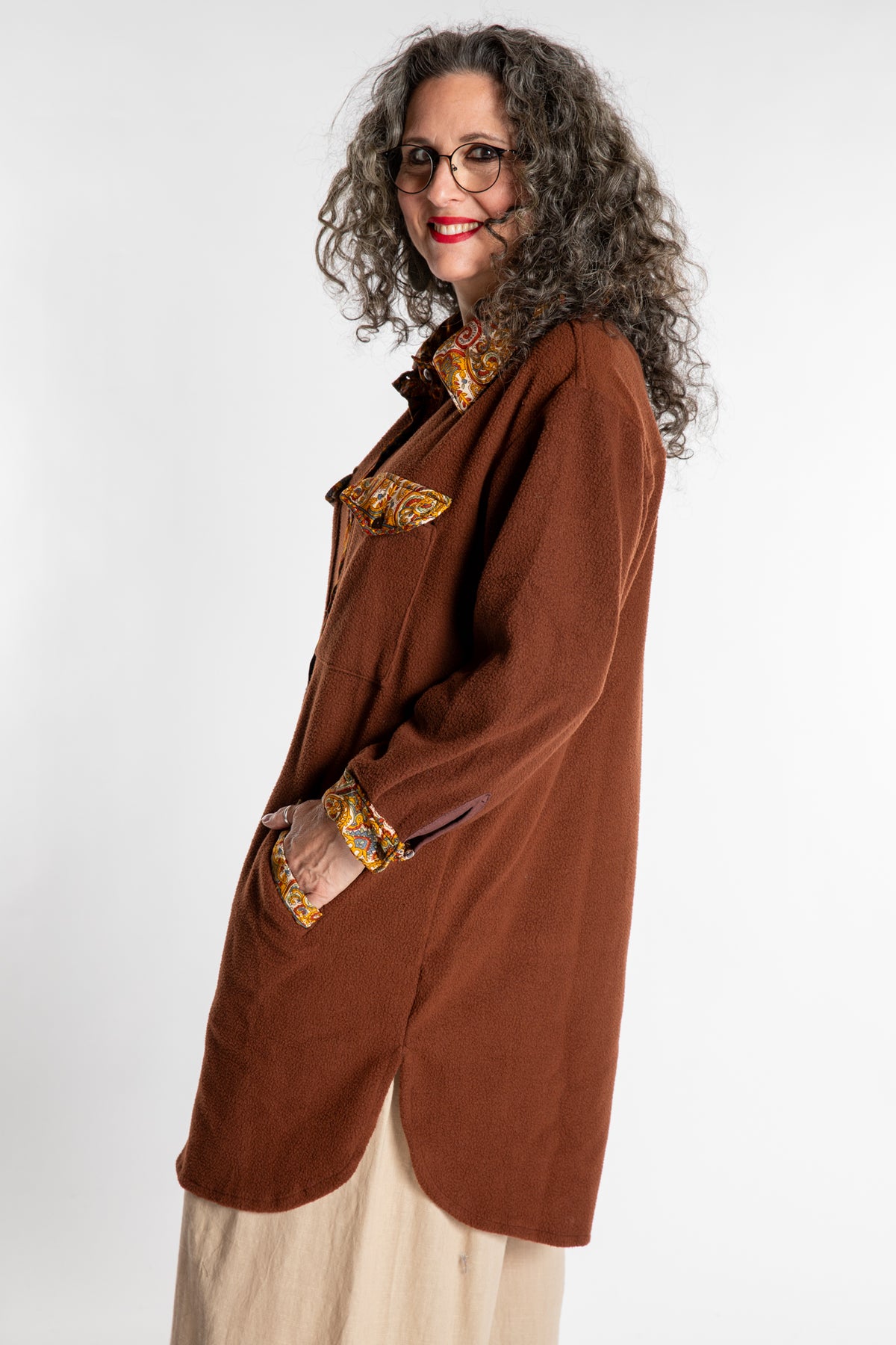 Susan is wearing the M/L Priya Patch Fleece Jacket in Rust