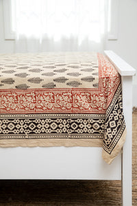 Bohemian block print tapestry in Black Feather, displayed as a bedspread