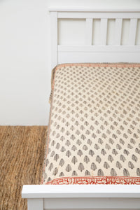 Bohemian block print tapestry in Black Feather, displayed as a bedspread