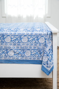 Bohemian block print tapestry in Blue Poppies, displayed as a bedspread