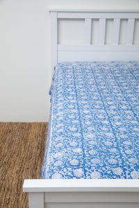 Bohemian block print tapestry in Blue Poppies, displayed as a bedspread