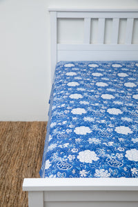 Bohemian block print tapestry in Blue Tropical Floral, displayed as a bedspread