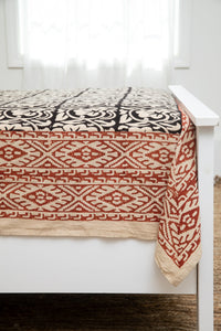 Bohemian block print tapestry in Crepuscular Vines, displayed as a bedspread