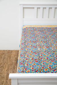 Bohemian block print tapestry in Fiesta Flowerpatch, displayed as a bedspread