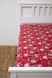 Bohemian block print tapestry in Garnet Profusion, displayed as a bedspread