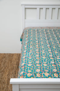 Bohemian block print tapestry in Jasmine Flower, displayed as a bedspread