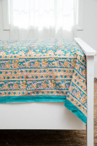 Bohemian block print tapestry in Jasmine Flower, displayed as a bedspread