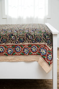 Bohemian block print tapestry in Midnight Vines, displayed as a bedspread