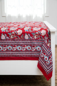 Bohemian block print tapestry in Ruby Reverie, displayed as a bedspread