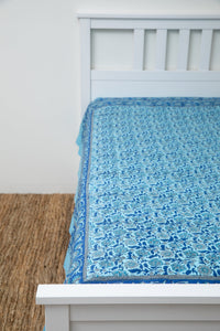 Bohemian block print tapestry in Turquoise Thistle, displayed as a bedspread
